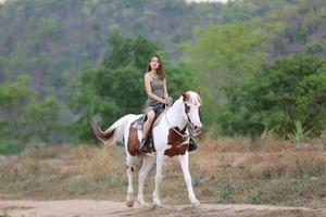 giovane donna con il suo cavallo nella luce del tramonto di sera. fotografia all'aperto con ragazza modella. umore dello stile di vita foto