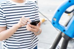 giovane donna asiatica che si prepara a caricare il suo veicolo elettrico o auto elettrica alla stazione di ricarica ev. veicolo elettrico - ev è l'energia alternativa per l'industria dei trasporti. foto