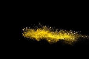 esplosione di polvere di colore giallo su sfondo nero. foto