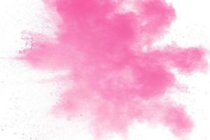 esplosione di polvere rosa astratta su sfondo bianco. congelare il movimento di polvere rosa schizzata. foto