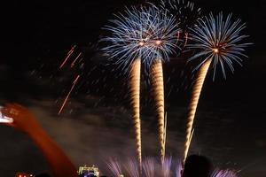 folla che guarda i fuochi d'artificio e celebra la città fondata. bellissimo spettacolo pirotecnico colorato nell'urbano per la celebrazione su sfondo notte oscura. foto