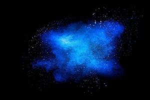 nuvola di esplosione di particelle di polvere di colore blu su sfondo nero. spruzzata di polvere di colore. foto