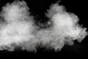 nuvola di esplosione di polvere bianca su sfondo nero. schizzi di particelle di polvere bianca. foto