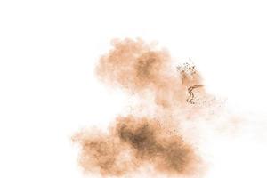 congelare il movimento della polvere marrone che esplode. disegno astratto della nuvola di polvere marrone su sfondo bianco. foto