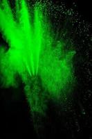 nuvola di esplosione di polvere di colore verde su sfondo nero. spruzzata di polvere verde sullo sfondo. foto
