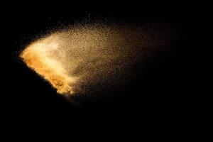 esplosione di sabbia di fiume secca isolata su sfondo nero. nuvola di sabbia astratta. spruzzata di sabbia colorata marrone su sfondo scuro. foto