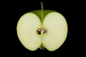 mela verde fresca e affettata isolata su sfondo nero. foto