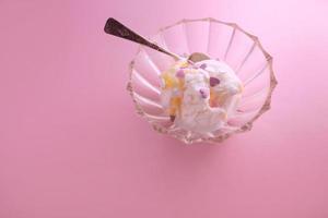 gelato sorbetto vegetariano bianco naturale con cuori dolci con cucchiaino in vaso su sfondo rosa foto