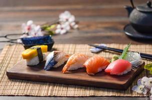 mescolare sushi su un piatto di legno, tonno, salmone, branzino, uova dolci, sushi di gamberetti, cibo giapponese foto