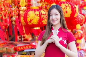 bella donna asiatica con i capelli lunghi che indossa un abito rosso cheongsam foto