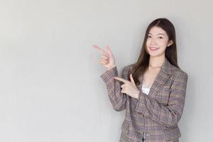 la donna professionista asiatica con i capelli lunghi neri che indossa un abito a quadri e piuttosto sorridente guardando la fotocamera è presente prodotto su sfondo bianco. foto