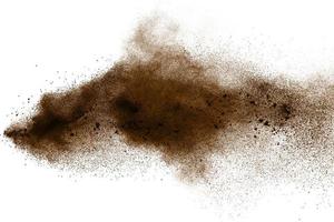 particelle marrone scuro schizzate su sfondo bianco. spruzzata di polvere marrone. foto