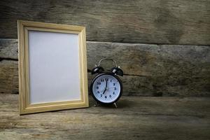 cornice per foto in legno e orologio su tavola di legno