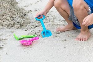 ragazzo gioca nella sabbia in spiaggia foto