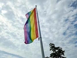 bandiera dell'orgoglio arcobaleno su un'asta di bandiera. simbolo della comunità lgbt nei colori dell'arcobaleno. foto