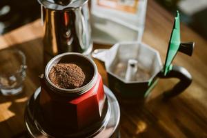 caffè macinato finemente e caffettiera vintage moka su tavola di legno a casa, messa a fuoco selettiva. foto