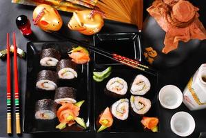 set di sushi con salmone e avocado su fondo di legno nero foto