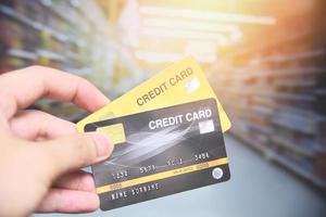 shopping con carta di credito al supermercato - mano che tiene il pagamento con carta di credito foto