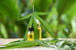 olio di cannabis su sfondo verde naturale - estratto di olio di cbd da foglie di marijuana di foglie di cannabis foto