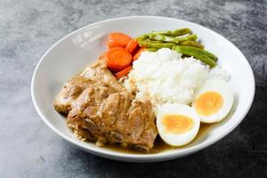 costine di maiale al forno con riso, uova sode e verdure foto