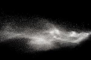 congelare il movimento di particelle di polvere bianca su sfondo nero. esplosione di polvere bianca. foto