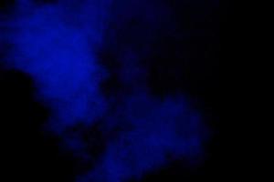 nuvola di esplosione di particelle di polvere di colore blu su sfondo nero. spruzzata di polvere di colore. foto