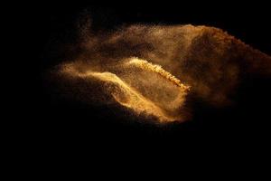 movimento astratto offuscata spruzzata di sabbia di colore marrone su sfondo nero. foto
