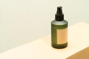 bottiglia cosmetica verde con etichetta isolata su sfondo bianco. primo piano flacone spray aromatico. concetto di biologico cruelty free. concetto di cosmetici naturali spa organici. foto