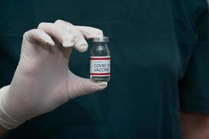 un medico che tiene il vaccino covid-19 nella bottiglia foto