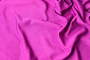 sfondo strutturato in tessuto rosa. tessuto per abbigliamento sportivo rosa in jersey testurizzato. foto