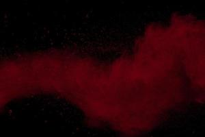 esplosione di polvere di colore rosso su sfondo nero. foto