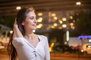 donna sorridente in una strada di città di notte foto