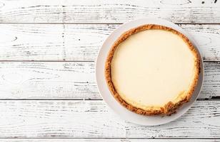 gustosa cheesecake fatta in casa su tavola di legno bianca foto