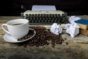 macchina da scrivere e caffè su fondo di legno foto