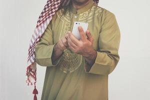 messaggistica araba dell'uomo d'affari su un telefono cellulare foto