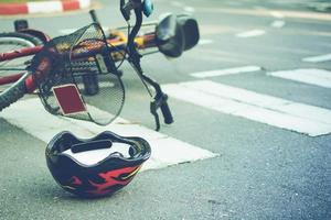 casco e bicicletta sdraiati sulla strada su un passaggio pedonale, dopo un incidente foto