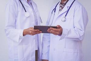 medici che controllano le informazioni sul paziente su un tablet foto