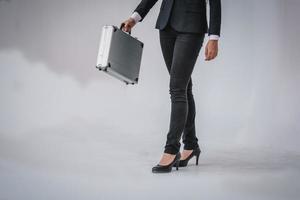 donna intelligente in abito nero tiene in mano una valigetta foto