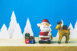 scatola di bambole di babbo natale e decorazioni natalizie su legno foto