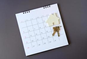 calendario e casa sul tavolo. giorno di acquisto o vendita di una casa o pagamento per affitto o prestito. foto