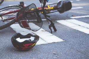 casco e bicicletta sdraiati sulla strada su un passaggio pedonale, dopo un incidente foto