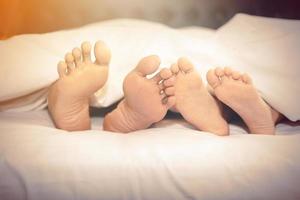 famiglia sul letto a casa con i piedi in mostra foto