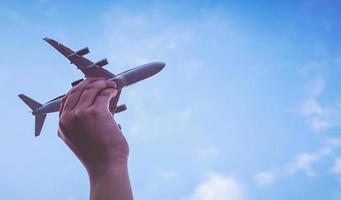 mani di bambino piccolo che tengono aeroplano foto