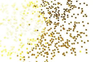 paillettes dorate a forma di stelle brillano su uno sfondo bianco. sfondi con copyspace per vacanze, decorazioni per feste, natale e capodanno, compleanno e anniversario. gradiente e consistenza foto