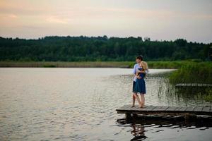 uomo e donna sul molo vicino al lago. foto