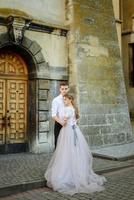 sposi di lusso che abbracciano e si baciano alla luce del sole. splendida sposa e sposo alla moda in un momento emotivo tenero sensuale. foto in bianco nero. ritratti