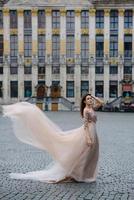 ritratto di una bella ragazza in un abito lussureggiante che passeggia per il parco e il grande palazzo foto