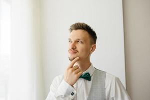 un uomo con un giubbotto si gratta la barba e distoglie lo sguardo. ha inventato qualcosa. foto