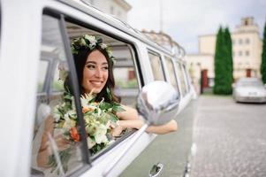 gli sposi hipster sono in piedi vicino al loro autobus retrò. foto