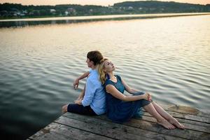 uomo e donna sul molo vicino al lago. foto